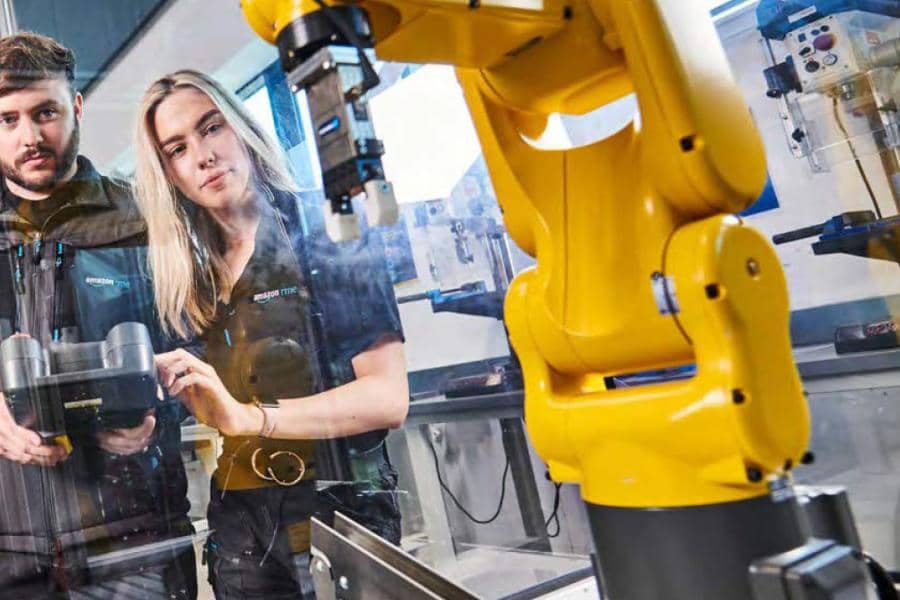 Two engineers using a robot in manufacturing